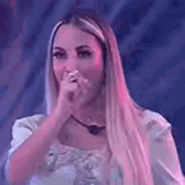 a woman is covering her mouth with her hand .