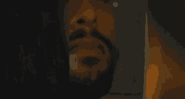 a close up of a person 's face in a car with a yellow light behind them