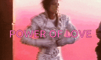 a man in a white suit is standing in front of a pink background with the words power of love above him