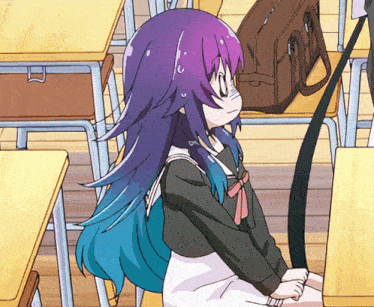 a girl with purple and blue hair sits at a desk