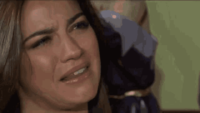 a close up of a woman 's face with a tear running down her face .