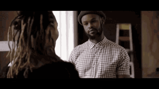 a man and a woman are standing next to each other in a room .
