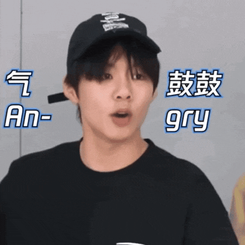 a young man wearing a black hat and a black t-shirt with chinese writing on it .