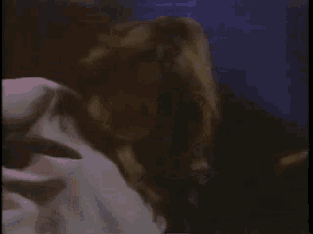 a woman with long hair is dancing in a dark room in a blurry photo .