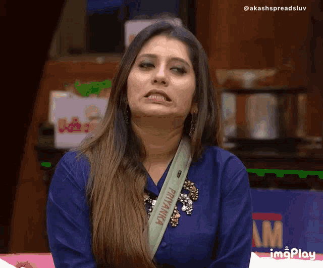 a woman wearing a blue shirt with a green strap that says priyanka on it