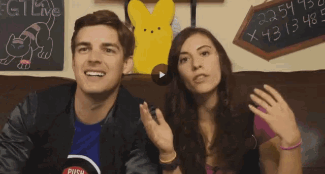 a man and a woman are sitting in front of a chalkboard that says fct live