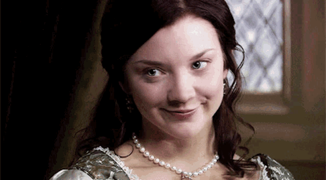a woman is wearing a pearl necklace and earrings