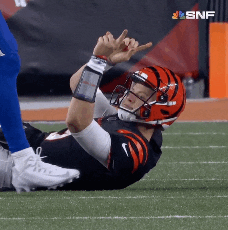 a football player is laying on the field with the snf logo in the background