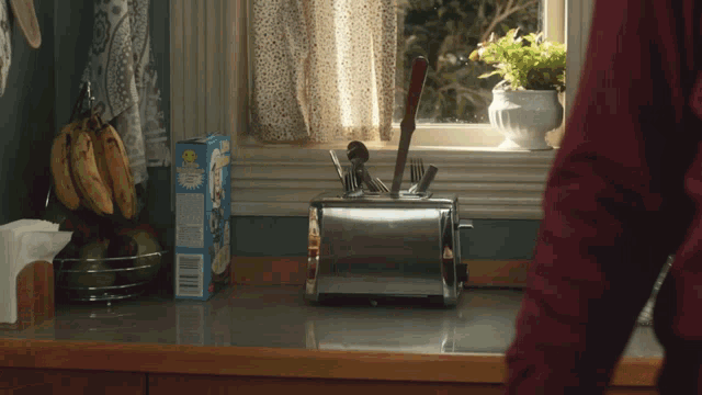a box of corn flakes sits on a kitchen counter next to a toaster
