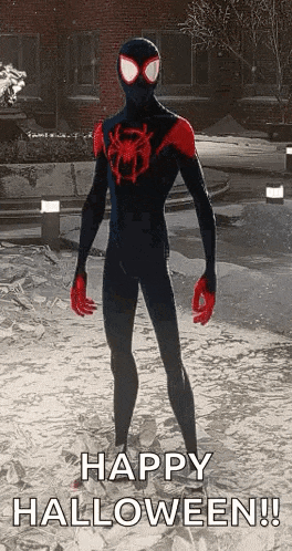 a man in a spiderman suit is standing in front of a building and says happy halloween .