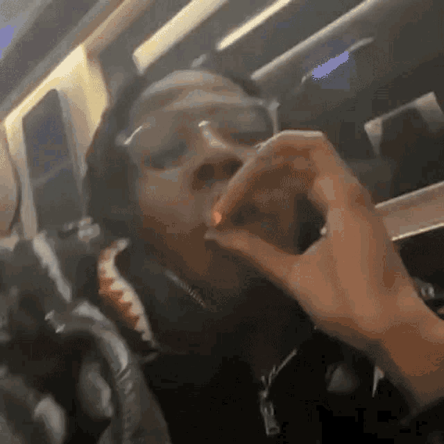 a man is smoking a cigarette on a plane while wearing glasses .