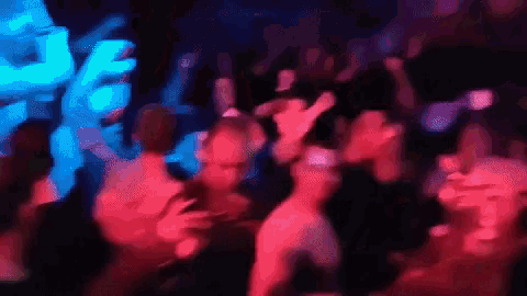 a blurry picture of a crowd of people dancing in a nightclub