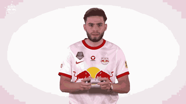 a man wearing a red bull jersey holds his fist up in the air