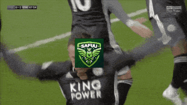 a soccer player wearing a king power jersey is hugging another player