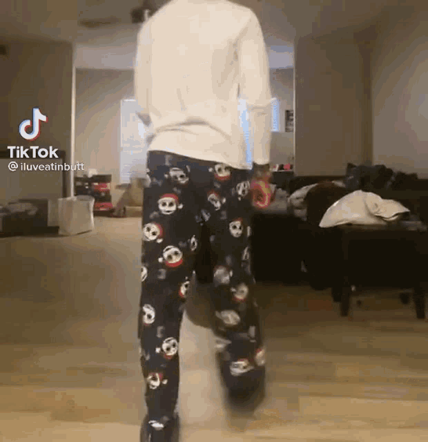 a person wearing skull pajamas is standing in a living room .