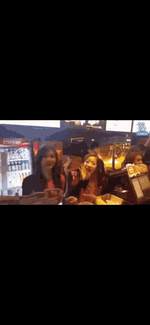 a blurry picture of a group of people sitting at a table eating food .