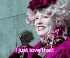 a woman in a pink dress is holding a microphone and saying `` i just love that '' .