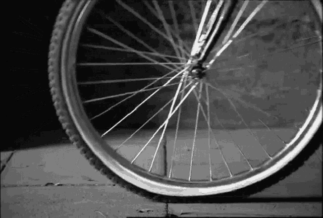 a close up of a bicycle wheel on a sidewalk