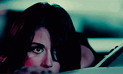 a close up of a woman 's face looking out of a car window