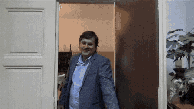 a man in a suit is walking through a doorway
