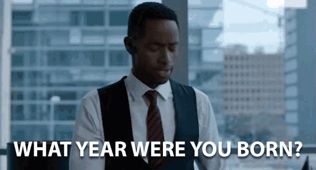 a man in a suit and tie is saying what year were you born