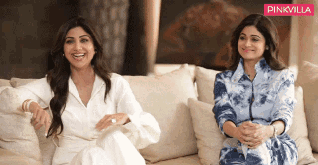 two women are sitting next to each other on a couch with a pinkvilla logo in the background
