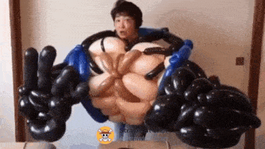 a man is standing next to a monster made of balloons