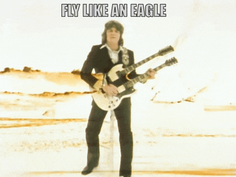 a man is playing two guitars with the words fly like an eagle above him