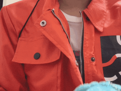 a person wearing a red jacket with a black button on the front