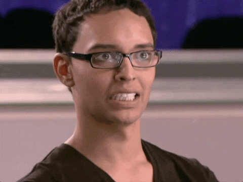 a man wearing glasses and a black shirt is making a face