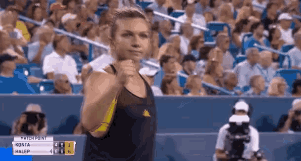 a tennis player is giving a fist bump in front of a crowd during a match .