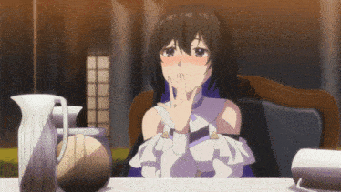 a girl with long black hair is sitting at a table with her hand on her face