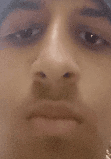 a close up of a young man 's face with a serious look on his face