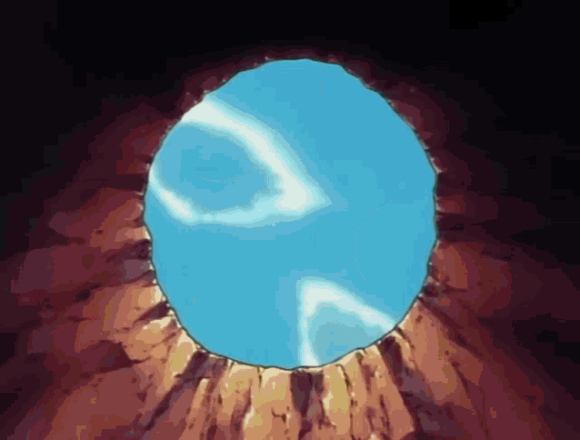 a hole in the ground with a blue sky visible