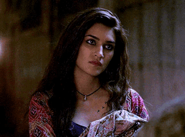 a woman with long hair is wearing a necklace and a scarf