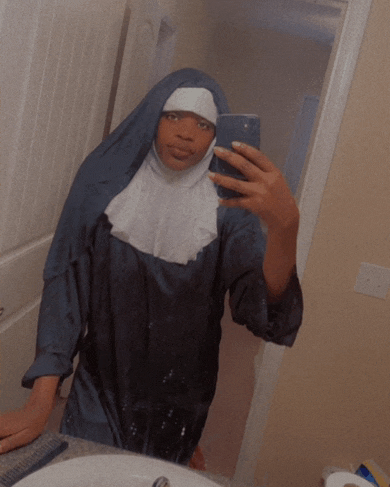a woman in a nun costume takes a selfie in front of a mirror