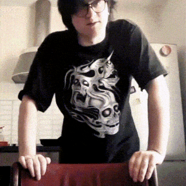 a young man wearing a black shirt with a skull on it