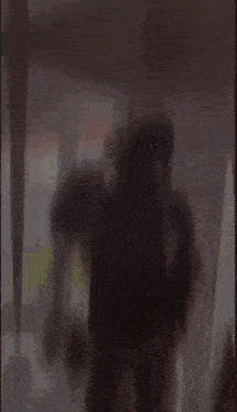 a blurred image of a person standing in front of a window .