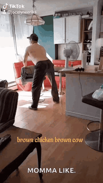 a man without a shirt is standing in a living room with the caption brown chicken brown cow momma like ..