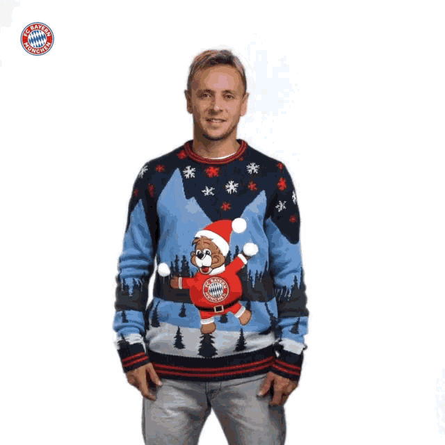 a man wearing a blue sweater with a teddy bear on it