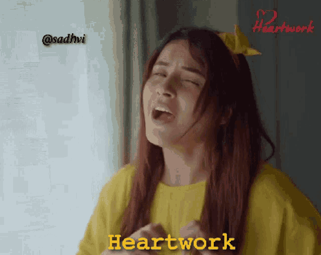 a woman with red hair is wearing a yellow shirt and has the word heartwork on her shirt