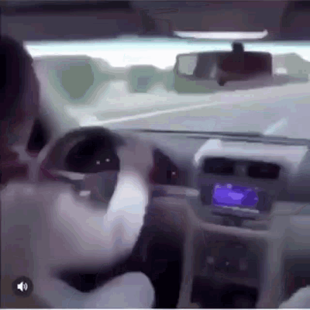 a man is driving a car on a highway and talking on the phone .