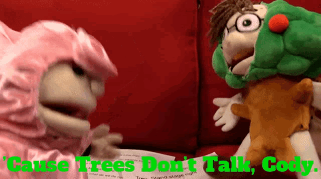 two stuffed animals are sitting on a red couch with the words cause trees don 't talk cody