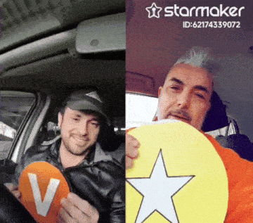 a man in a car holding a sign that says v