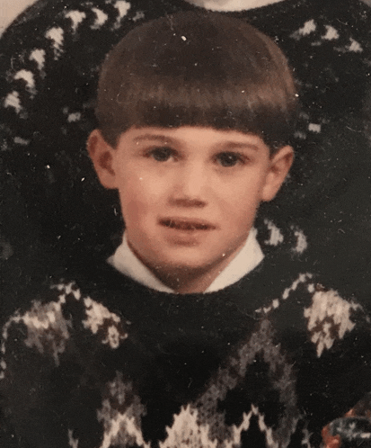 a young boy is wearing a black and white sweater and a white shirt