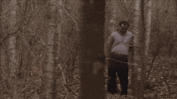 a man in a blindfold is standing in a forest