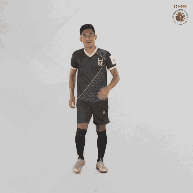 a man in a black shirt and shorts stands in front of a white background with a hero logo on it