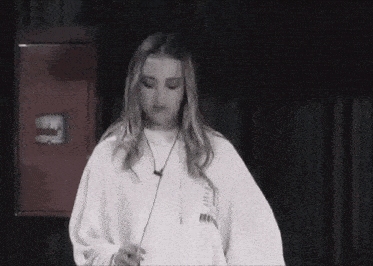 a black and white photo of a woman wearing a white sweatshirt with the word freedom on the back