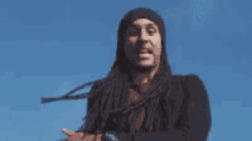 a man with long dreadlocks is wearing a beanie and a watch .