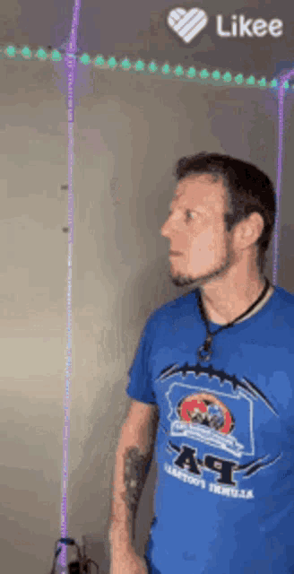 a man wearing a blue shirt that says a.t. on it